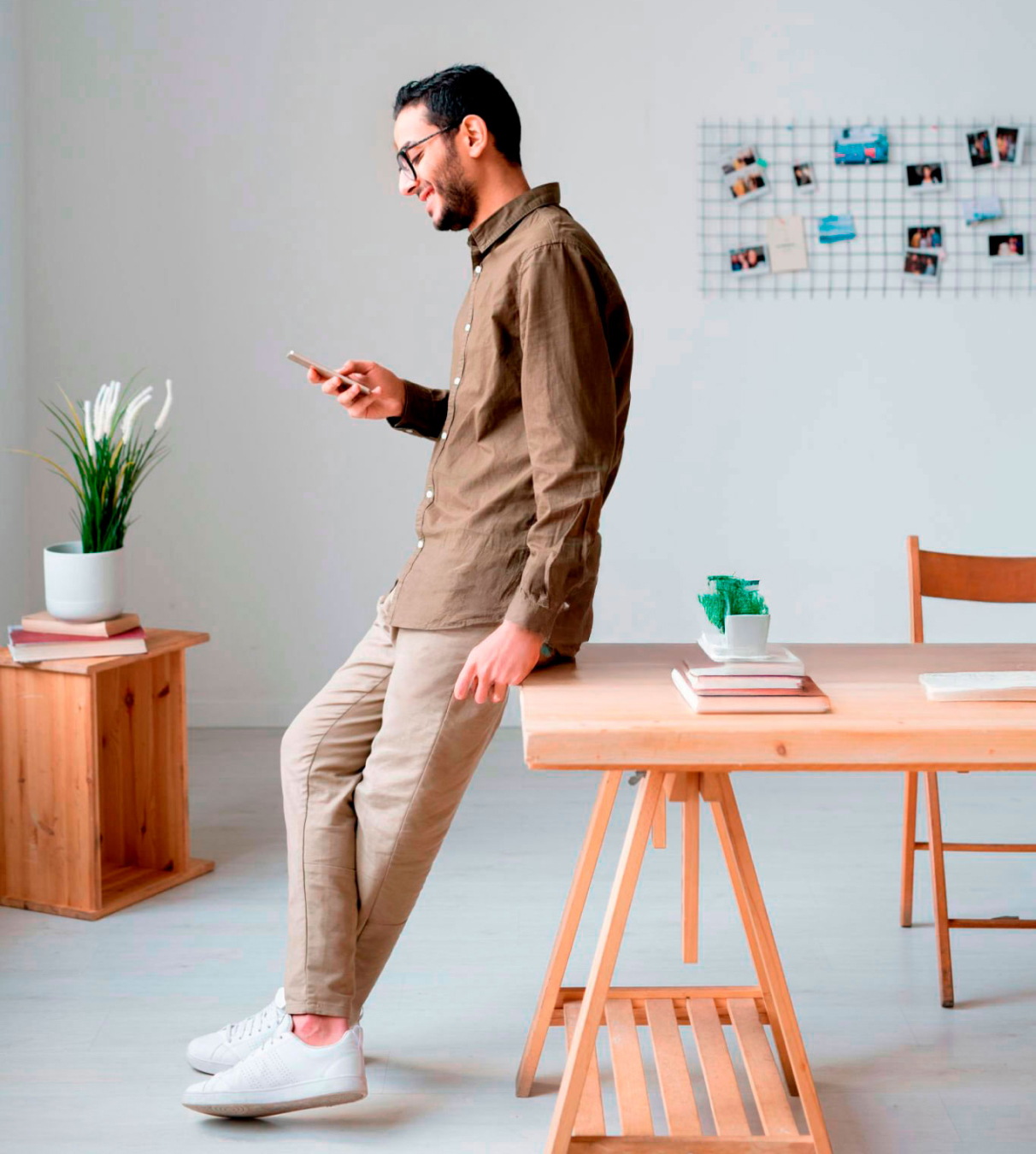 Hombre con un móvil apoyado en una mesa